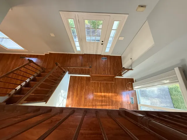 an empty room with windows and fan