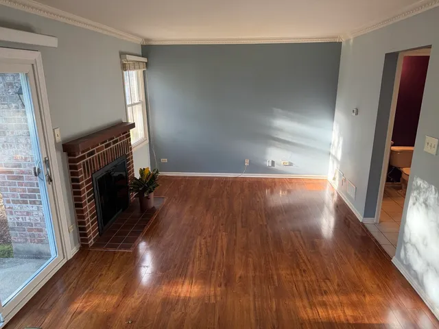 a view of a livingroom with wooden floor and a fireplace