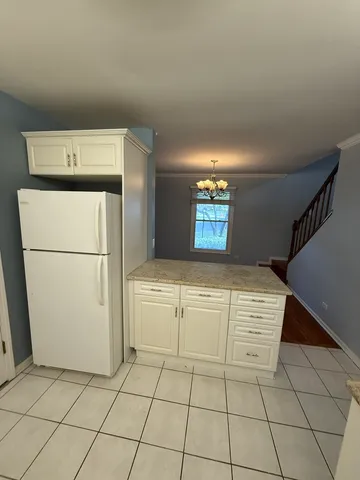 a kitchen with granite countertop a refrigerator a stove a washer and dryer