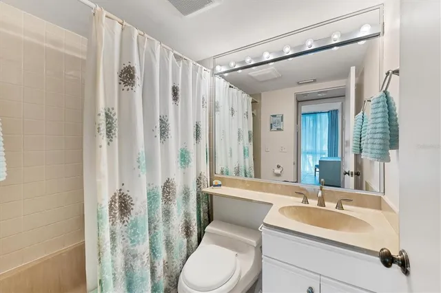 a bathroom with a toilet a sink and a large mirror