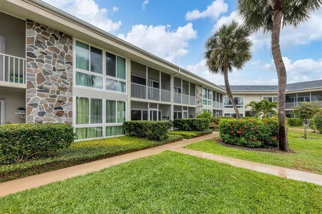 a front view of a house with a yard and potted plants