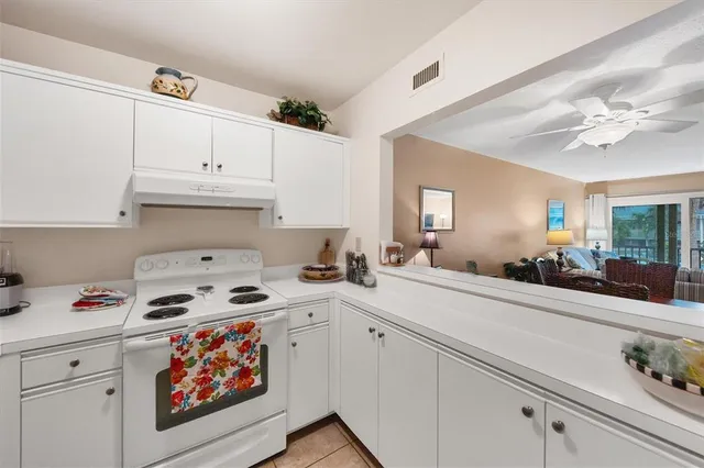 a kitchen with stainless steel appliances a white stove top oven and white cabinets