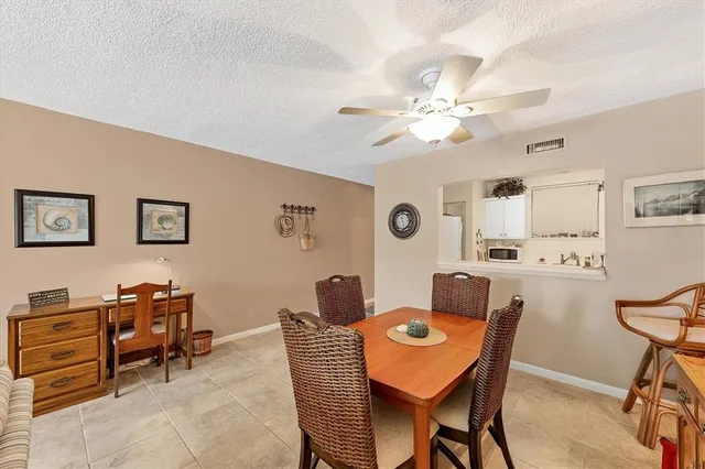a view of a dining room with furniture and a chandelier fan