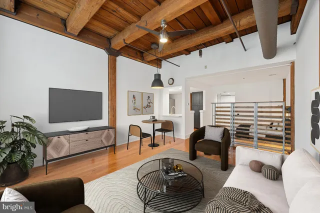a living room with furniture a dining table and a flat screen tv with wooden floor
