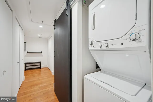 a view of washer and dryer with bathroom in the background