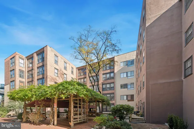 a front view of a multi story residential apartment building with a yard
