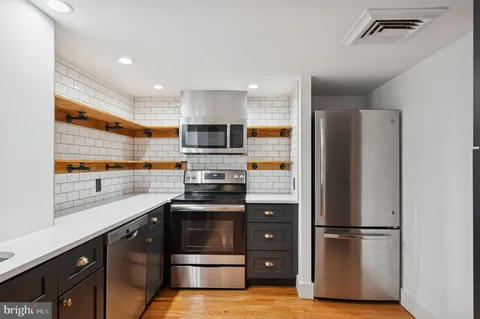 a kitchen with a refrigerator and white cabinets
