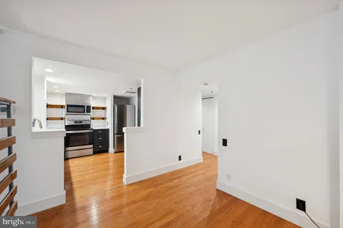 a view of a kitchen with wooden floor and electronic appliances