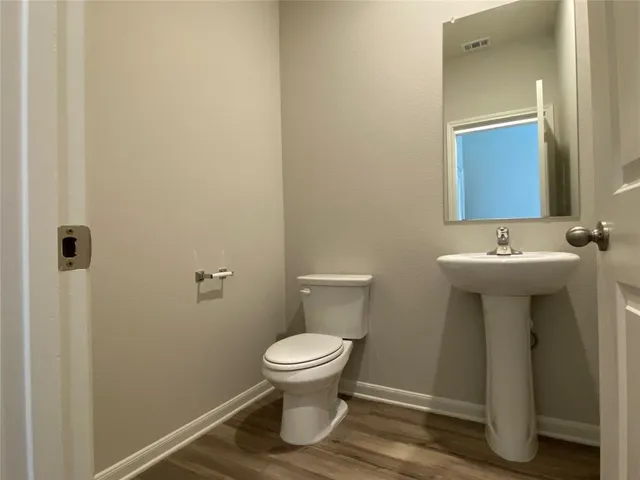 a view of a utility room with closet and wooden floor
