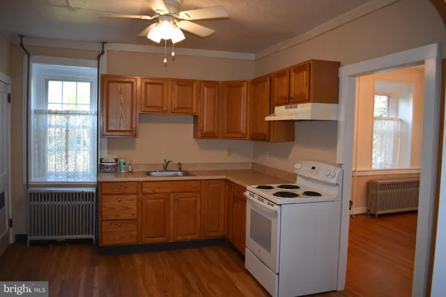 a kitchen with stainless steel appliances granite countertop a sink a stove cabinets and wooden floor