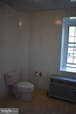 a bathroom with a toilet a sink and a window