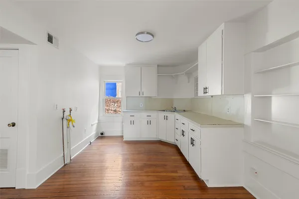 a kitchen with cabinets a sink and wooden floor