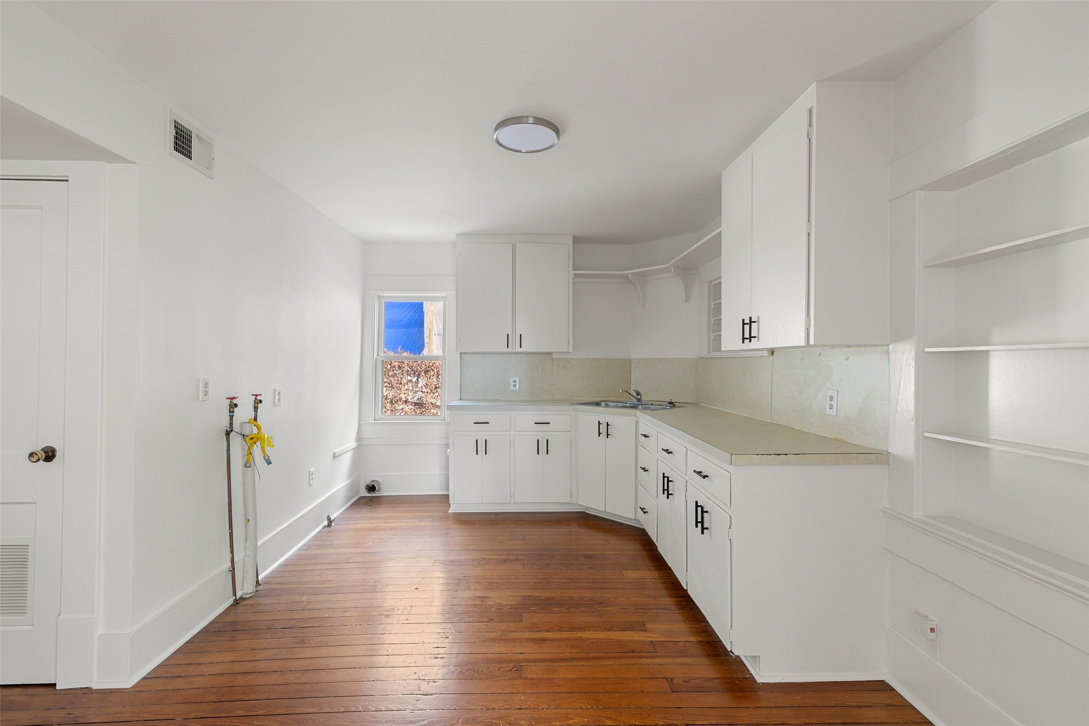 613 Baylor Street Austin, TX 78703 - Photo 24 of 40 a kitchen with cabinets a sink and wooden floor