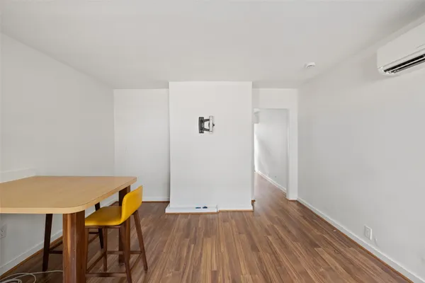 a view of a room with wooden floor and dining room