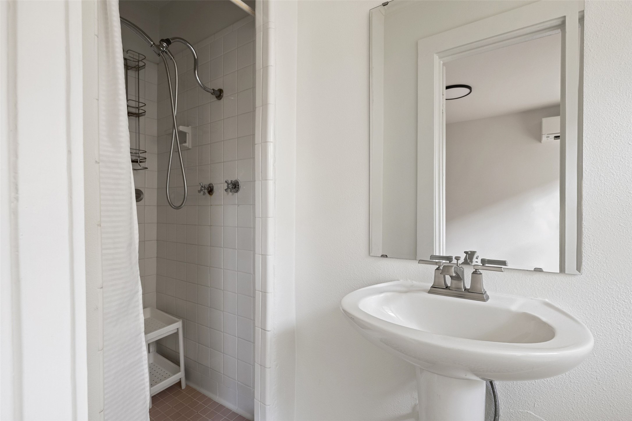 613 Baylor Street Austin, TX 78703 - Photo 39 of 40 a bathroom with a sink a mirror and a shower