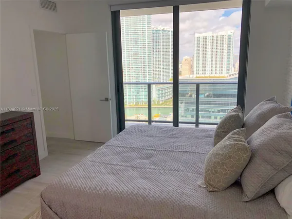 a bed sitting in a bedroom next to a window