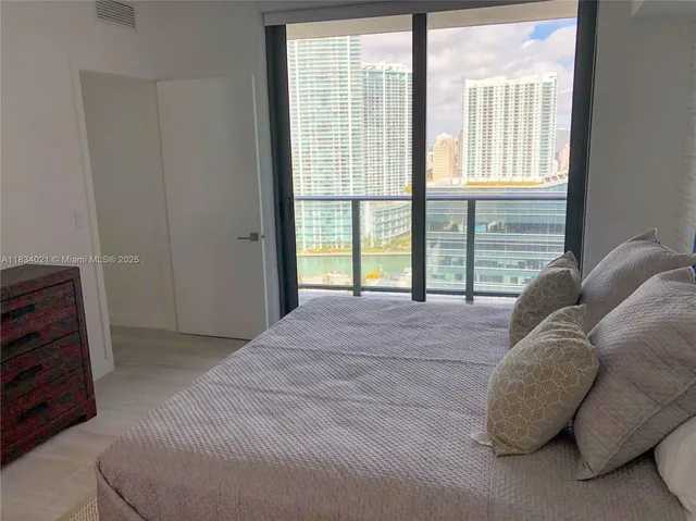 a bed sitting in a bedroom next to a window