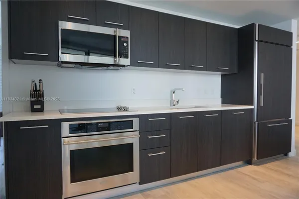 a kitchen with stainless steel appliances granite countertop a stove microwave and refrigerator