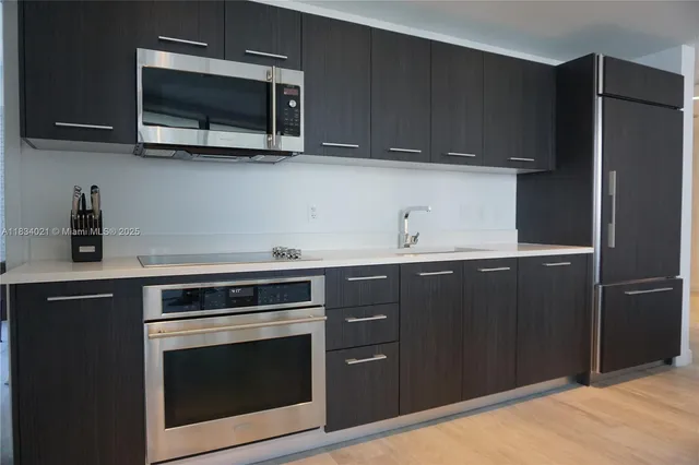 a kitchen with stainless steel appliances granite countertop a stove microwave and refrigerator