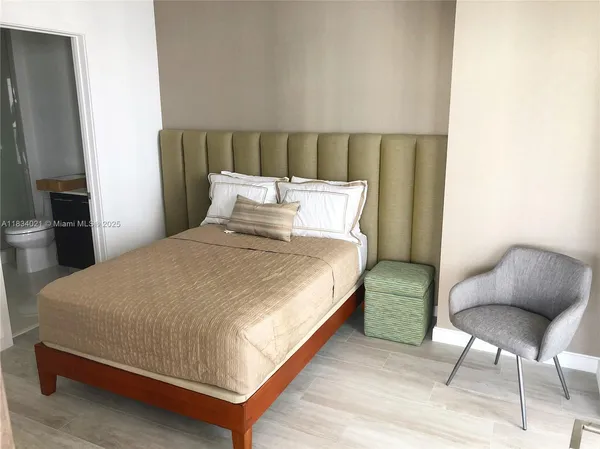 a bed sitting in a bedroom and chair