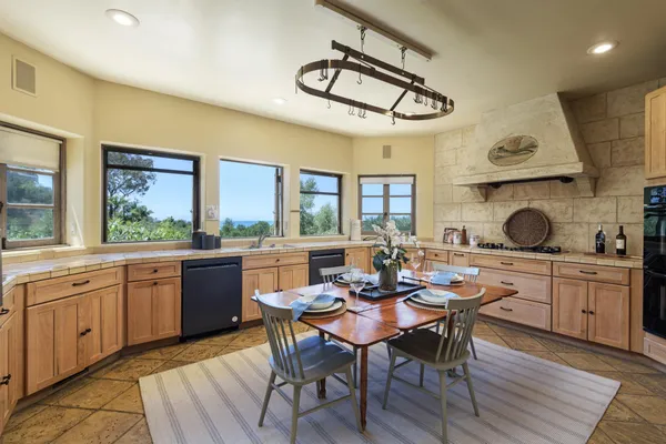 a kitchen with a dining table chairs and white appliances