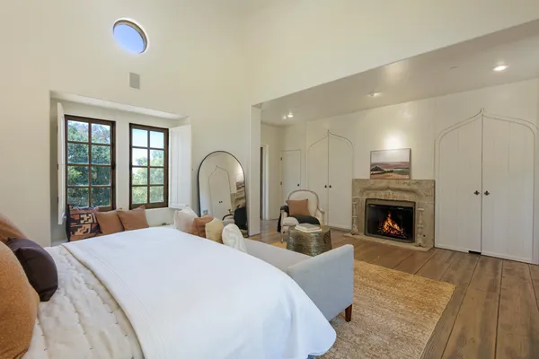 a large bedroom with bed and a fireplace