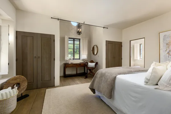 a bedroom with a bed a couch and a window