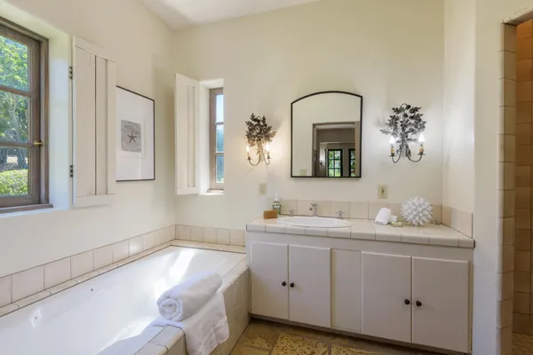 a bathroom with a double vanity sink and mirror with window