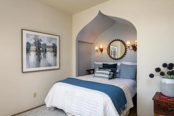 a bedroom with bed and a mirror