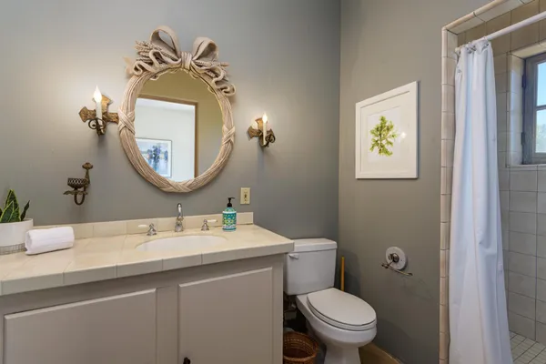 a bathroom with a toilet sink and mirror