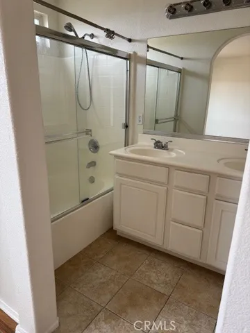 a large bathroom with a double vanity sink a mirror and a bathtub