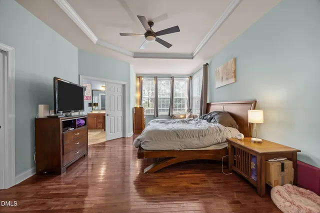 a spacious bedroom with a bed and a flat screen tv