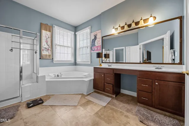 a spacious bathroom with a tub sink and mirror