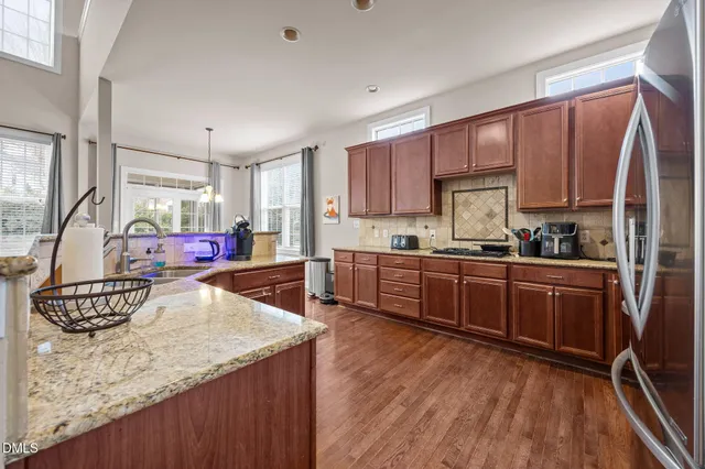 a kitchen with stainless steel appliances granite countertop a refrigerator sink and cabinets