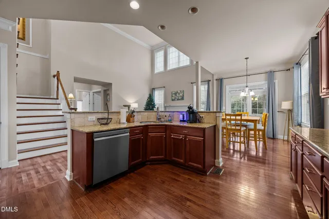 a kitchen with stainless steel appliances granite countertop a stove and a wooden floors