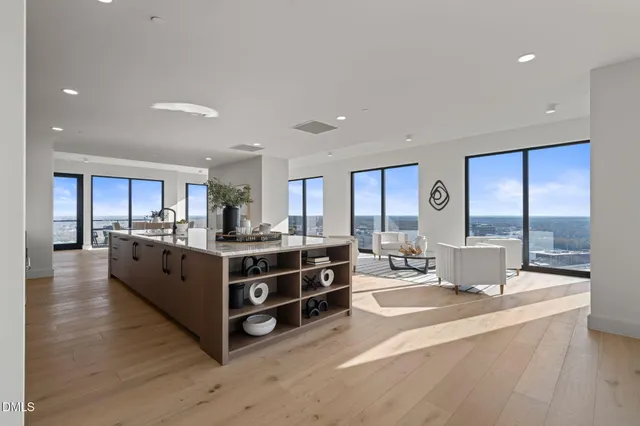 a living room with stainless steel appliances kitchen island granite countertop a large cabinets and wooden floor