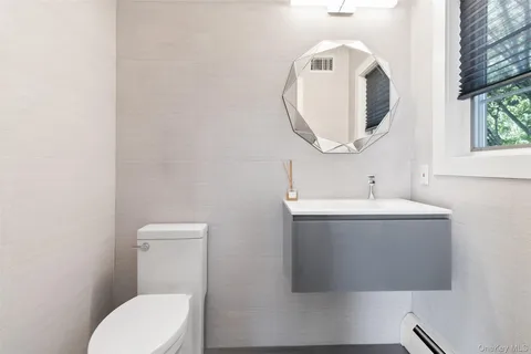 a bathroom with a sink and mirror with toilet