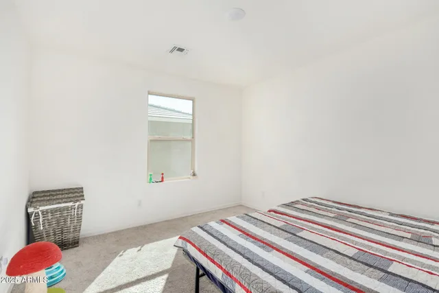 a bedroom with a bed window and dresser