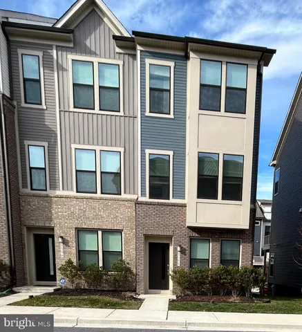 a front view of a house with yard and parking space
