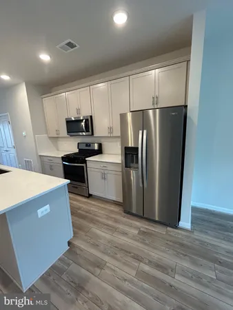 a kitchen with stainless steel appliances a refrigerator a stove a sink and a microwave