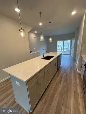 a kitchen with sink and wooden floor