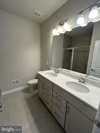 a bathroom with a double vanity sink mirror and toilet