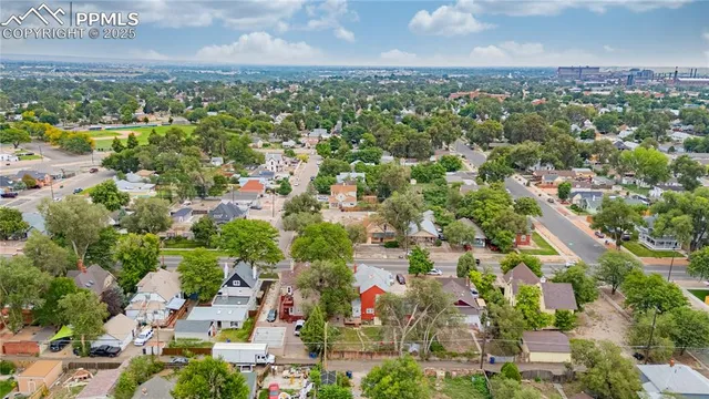 an aerial view of residential houses with outdoor space and trees