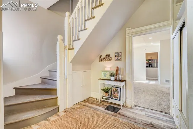 a view of entryway and hall with wooden floor