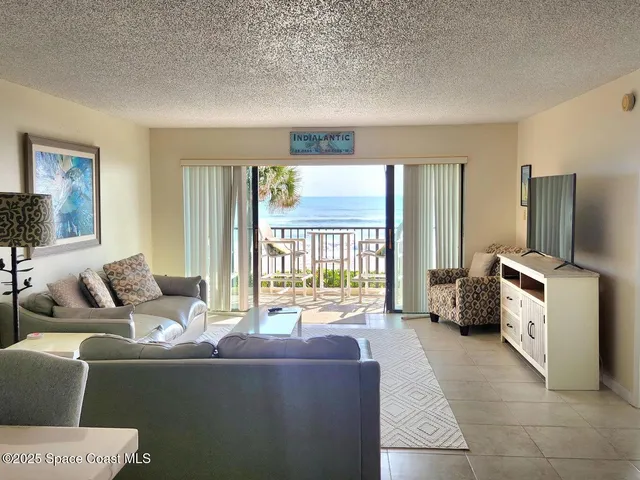 a view of a dining room with furniture and a chandelier