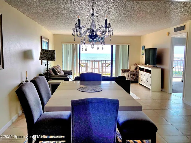 a living room with furniture a flat screen tv and kitchen view