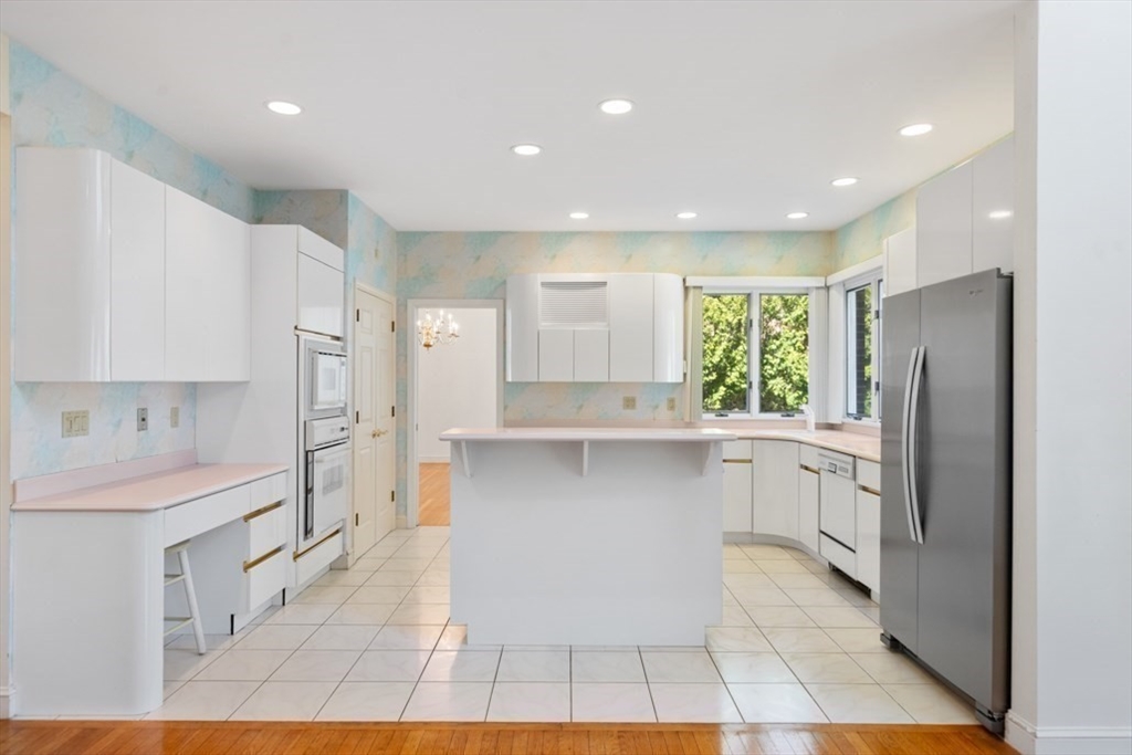 49 Forest Street Saugus, MA 01906 - Photo 13 of 42 a large white kitchen with a large window a refrigerator and a sink