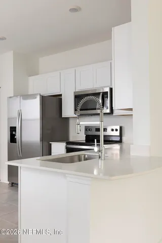 a kitchen with kitchen island a counter top space stainless steel appliances and cabinets