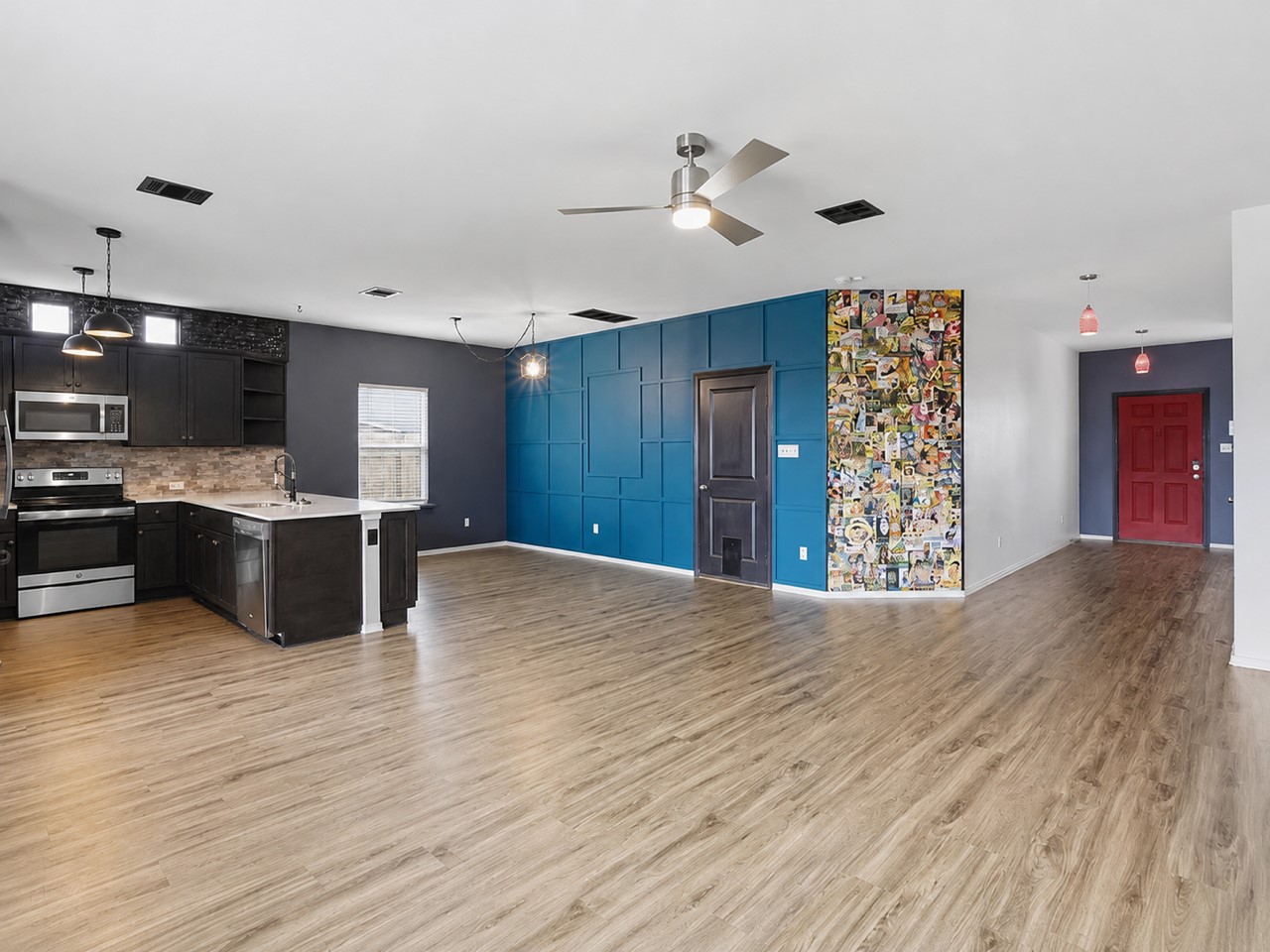 116 Night Riders Way Jarrell, TX 76537 - Photo 12 of 38 An open-concept living area features a modern kitchen island and warm wood flooring throughout.
