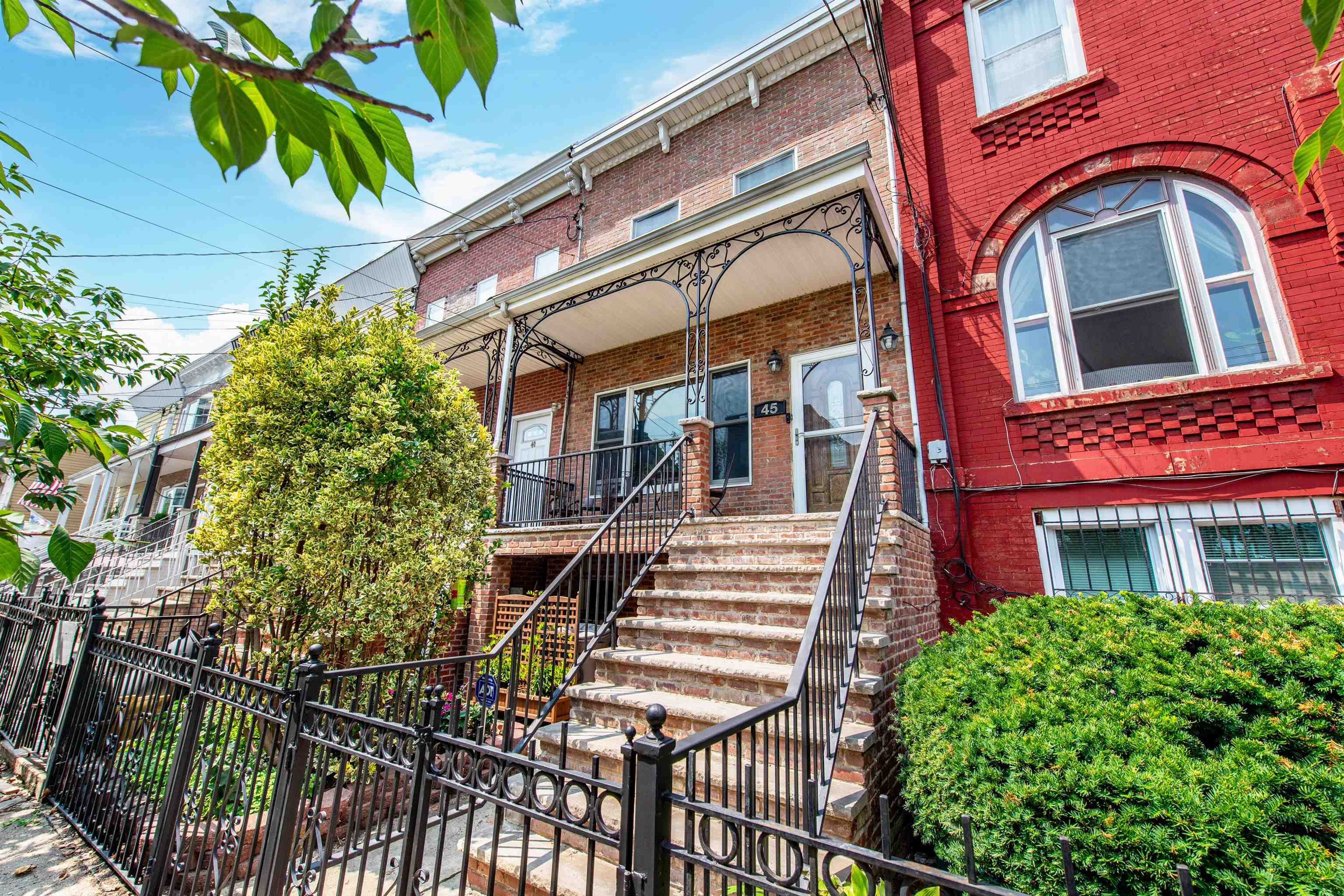 45 Monitor Street, Unit 1 Jersey City, NJ 07304 - Photo 14 of 14 a front view of a multi story residential apartment building with a yard